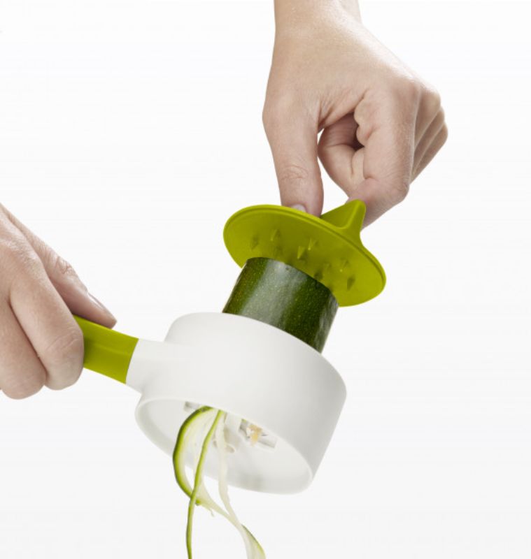 Compact green spiralizer with long handle, stainless-steel blade, and finger guard for safe, easy vegetable noodle making.