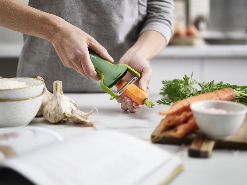 Joseph Joseph SafeStore Straight Peeler in green with stainless-steel blade and integrated guard for safe storage and peeling.