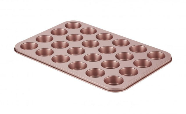 Rose gold muffin pan with 24 cups, non-stick, embossed measurements, and removable base for easy baking and cleanup.