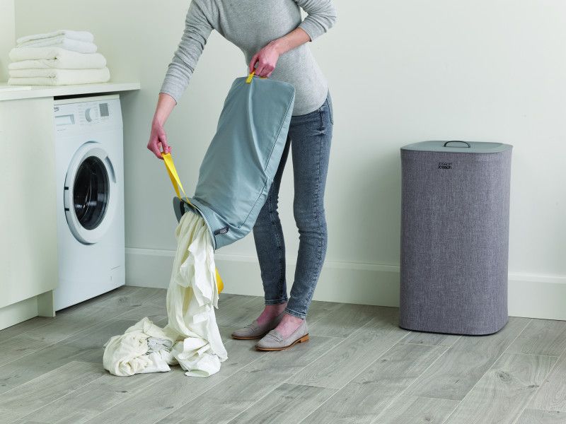 Joseph Joseph Tota 60-litre laundry basket in grey, featuring dual compartments and removable tote bags for easy fabric separation.