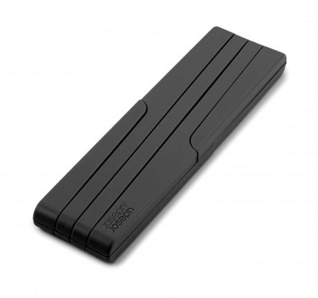 Expandable black silicone trivet from Joseph Joseph, heat-resistant and foldable for easy storage in modern kitchens.