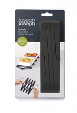 Expandable black silicone trivet with heat resistance; folds neatly for easy storage in modern kitchens.