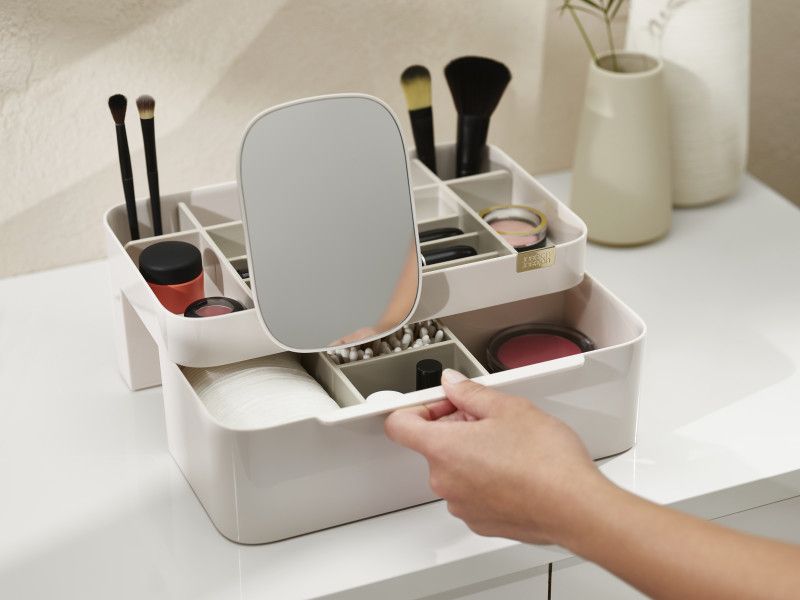 Large shell cosmetic organizer with deep and shallow compartments, removable mirror, and easy-pull drawer for beauty tools.