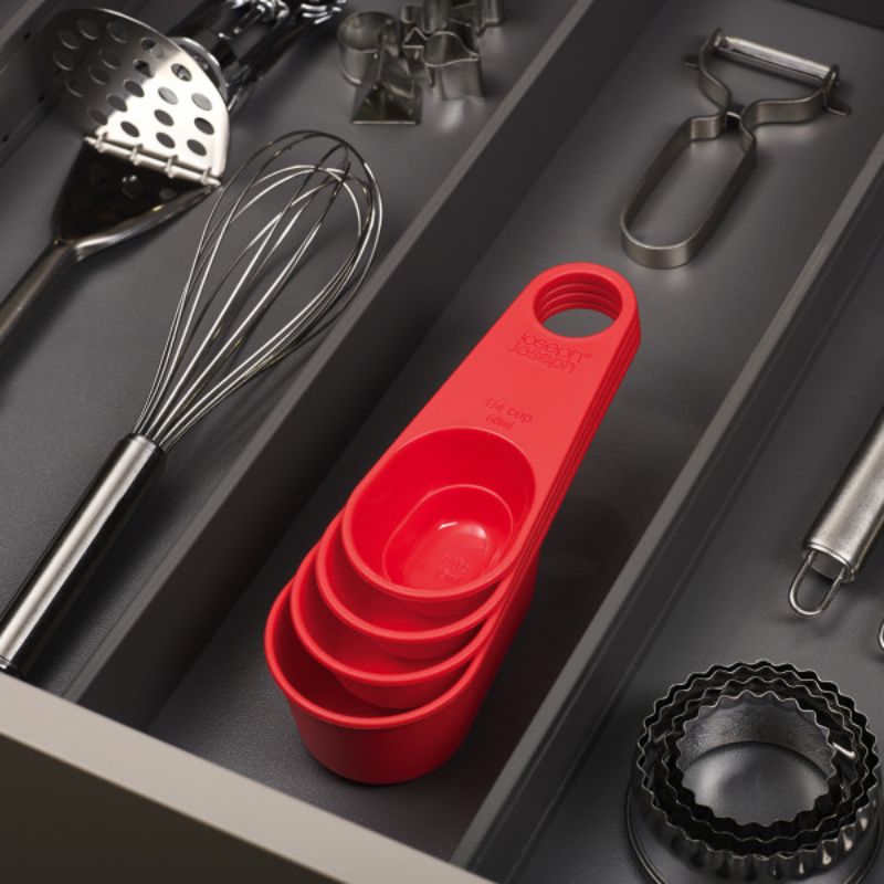 Stylish red 4Pc measuring cup set with space-saving design and clip-together handles for easy storage and precise measurements.