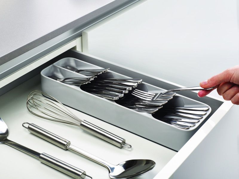 Compact cutlery organizer with layered compartments for efficient storage of utensils in small kitchen drawers.