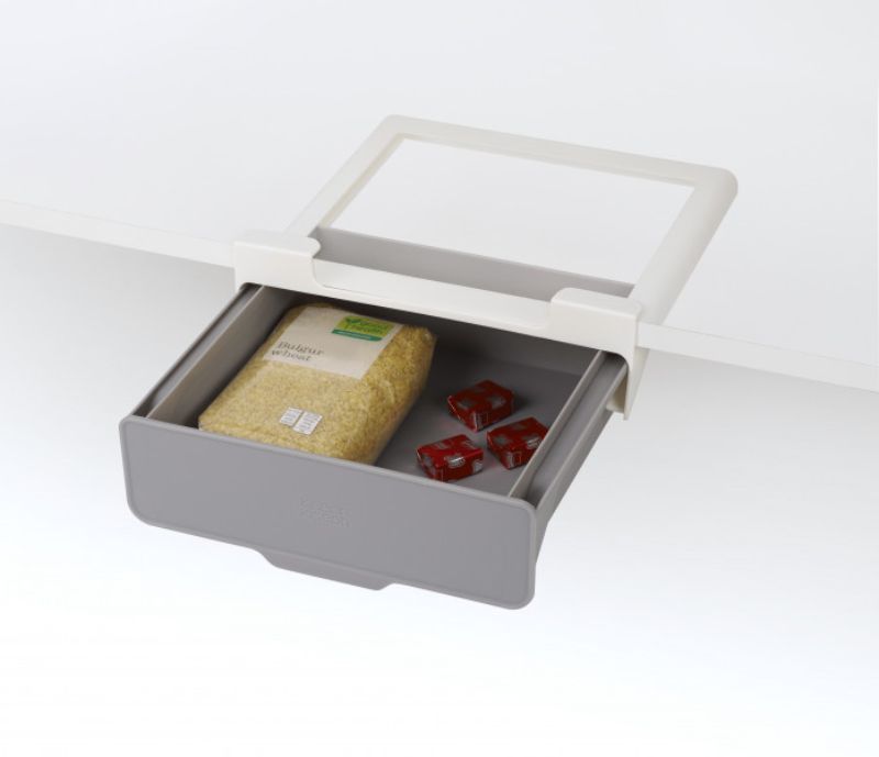 Under-shelf drawer by Joseph Joseph for maximizing kitchen storage and organizing loose items. Easy installation with tape.