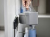 Joseph Joseph DoorStore In-cupboard Sink Tidy in Grey, featuring divided compartments and a stainless-steel rail for organizing cleaning supplies.